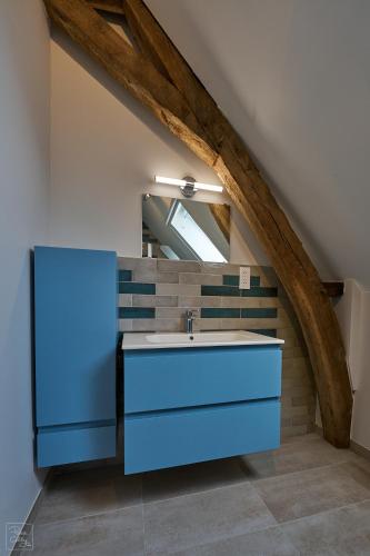 a bathroom with a blue sink in an attic at Les Campanes - Gite 8 personnes avec piscine intérieure et sauna 