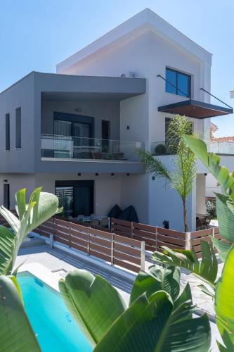 a house with a swimming pool in front of it at Diamond Gold Suite in Iraklitsa
