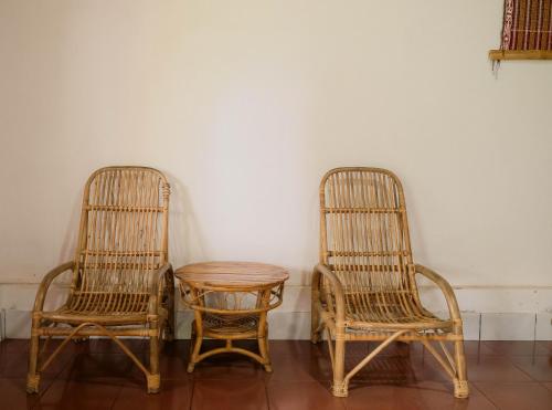 two rattan chairs and a table in a room at Ecolodge Bukit Lawang in Bukit Lawang