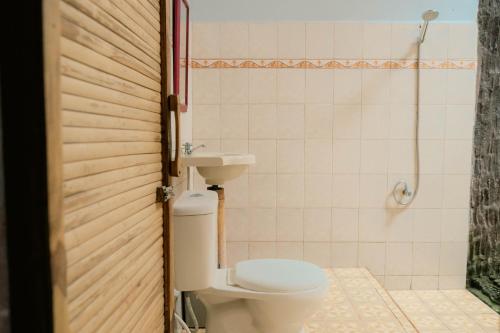 a bathroom with a toilet and a sink and a shower at Ecolodge Bukit Lawang in Bukit Lawang