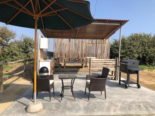 a patio with a table and chairs and a grill at Casa de Campo La Martina con piscina y parrilla in Tambo de Mora