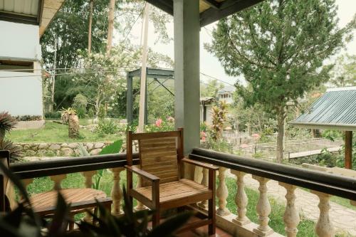 a porch with two chairs and a view of a yard at Ecolodge Bukit Lawang in Bukit Lawang