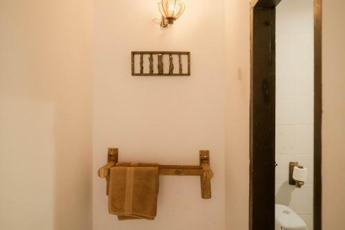 a bathroom with a towel rack and a toilet at Ecolodge Bukit Lawang in Bukit Lawang