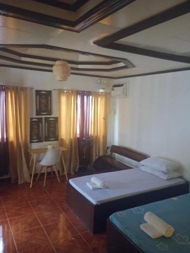 a bedroom with two beds and a table with a chair at Zia Homestay in Burgos
