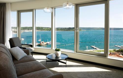ein Wohnzimmer mit einem großen Fenster mit Blick auf das Wasser in der Unterkunft Hotel Slovenija - Terme & Wellness LifeClass in Portorož