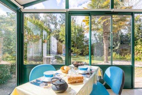 a table with food on it in a room with windows at Gîte Du Peintre in Challans