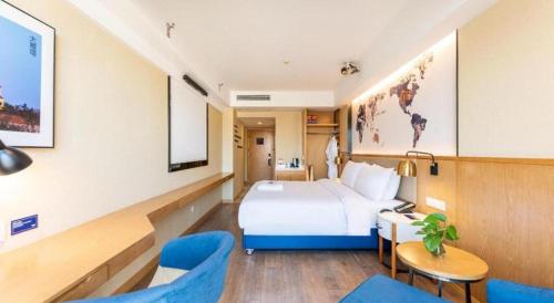 a hotel room with a bed and a table and chairs at Kyriad Marvelous Hotel·Xi'an North High-speed Railway Station in Xi'an