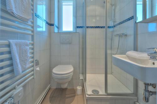ein Bad mit einem WC, einem Waschbecken und einer Dusche in der Unterkunft Hotel Morgensonne garni in Büsum