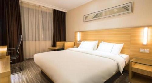 a large white bed in a hotel room at City Comfort Inn Wuhan High Speed Railway Station in Wuhan