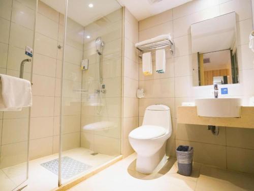 a bathroom with a toilet and a shower and a sink at City Comfort Inn Wuhan High Speed Railway Station in Wuhan
