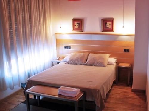 1 dormitorio con 1 cama grande y 2 mesas en Hotel Trefacio, en Zamora