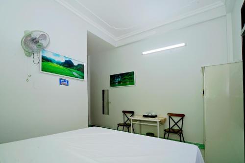 a bedroom with a bed and a table and chairs at Hoalu Rosa Hotel in Ninh Binh