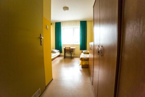 un corridoio con una stanza con pareti gialle e un tavolo di Ondraszka a Katowice
