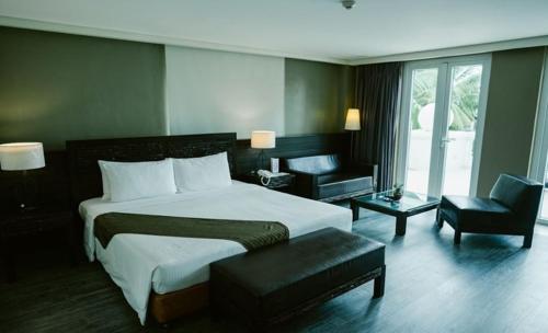 a hotel room with a large bed and a chair at Boracay Sands Hotel in Boracay