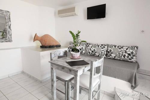 a dining room with a table and a couch at Villa Happening in Imerovigli