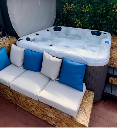 a jacuzzi tub sitting next to a white couch at O CANTINHO DA RIA - JACUZZI with water at 35 degrees and POOL in Torreira