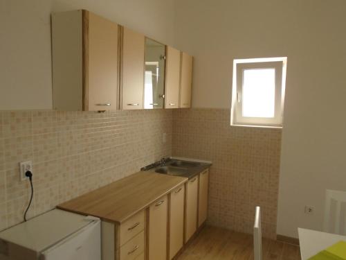 eine leere Küche mit einem Waschbecken und einem Fenster in der Unterkunft Apartments Kanli Kula in Herceg-Novi