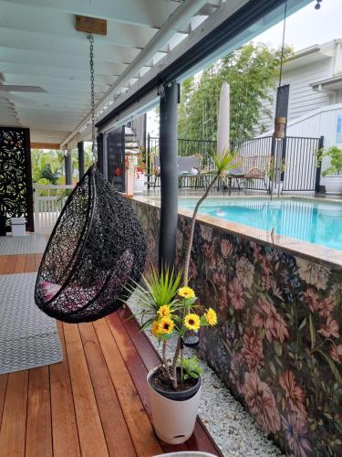 a hammock on a porch next to a swimming pool at Tranquil Beach Getaway in Coolum Beach