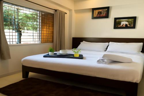 a bedroom with a large bed with a tray on it at Kamal Farm Resort in Shenwa