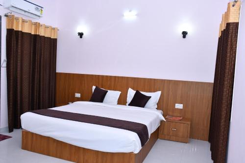 a bedroom with a large bed with white sheets at Hotel Prayagraj in Rīngas