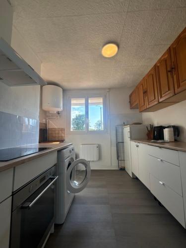 a small kitchen with a washing machine in it at Appartement T3 in Roanne