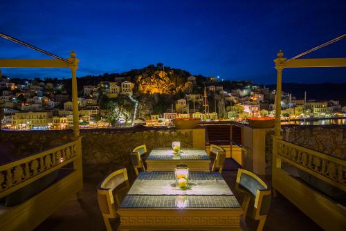a table on a balcony with a view of a city at The Old Markets in Symi