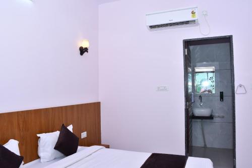 a bedroom with a bed and a bathroom with a sink at Hotel Prayagraj in Rīngas
