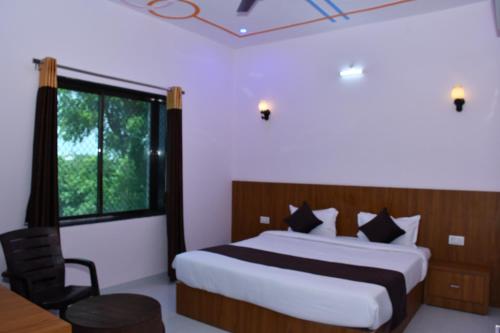 a bedroom with a large bed and a window at Hotel Prayagraj in Rīngas