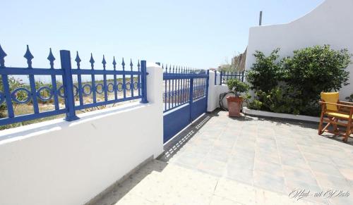 a blue fence on a white wall with a patio at Villa Happening in Imerovigli