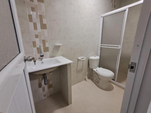 a bathroom with a shower and a toilet and a sink at Casa Hotel Luisa in Cartagena de Indias