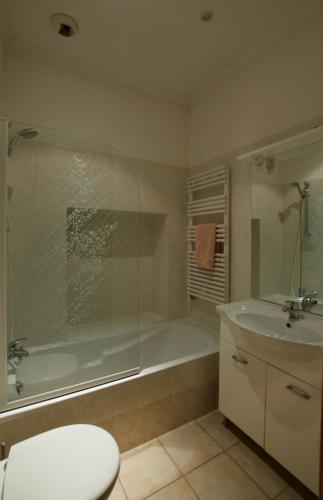 une salle de bain avec une baignoire, des toilettes et un lavabo dans l'établissement Appartement les clematites, à Menton