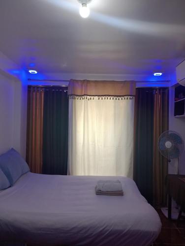 a bedroom with a white bed with blue lights at Zia Homestay in Burgos