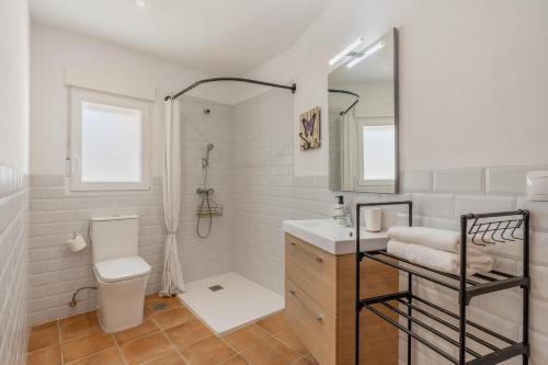 a bathroom with a toilet and a sink and a mirror at Casa Mercedes In Granada's Vega in Valderrubio