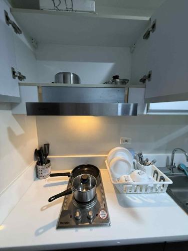 a kitchen counter with a stove with a pot on it at Makati One Bed Room with Balcony Air Residence SMDC in Sampong
