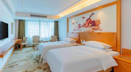a hotel room with two beds and a television at Out Sky Hotel in Huizhou