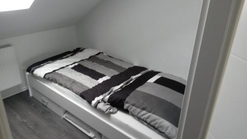 a bunk bed with a striped blanket on it at Ferienwohnung Wesertraum in Hannoversch Münden