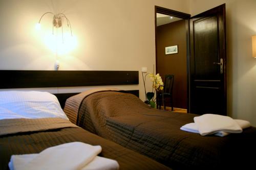1 dormitorio con 2 camas y una luz en la pared en Apartamenty Astur, en Cracovia