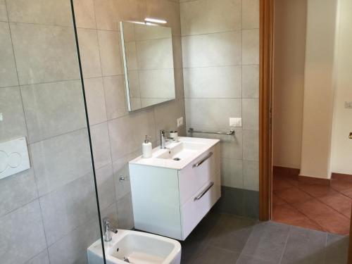 a bathroom with a sink and a toilet and a mirror at Roma Suite Cinecittà in Rome