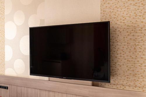 a large flat screen tv sitting on a wall at Kyoto Tokyu Hotel in Kyoto