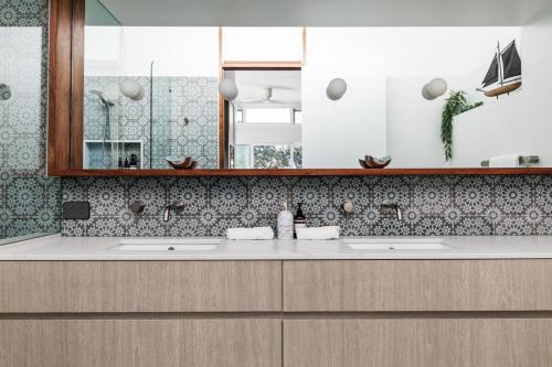 a bathroom with two sinks and a mirror at Pool House, luxury 2 bedroom with ocean views, pool and sauna in Lennox Head
