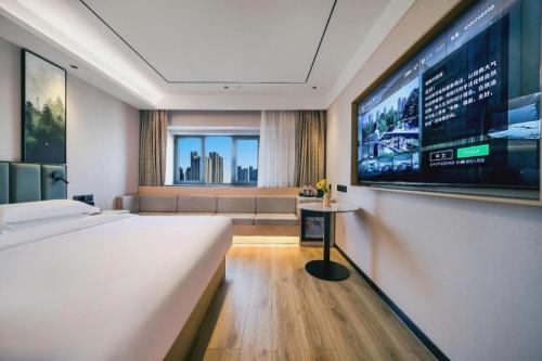 une chambre d'hôtel avec un grand lit et une télévision dans l'établissement GreenTree Inn Beijing Changping District North China Electric Power University Business Hotel, à Yongfengtun