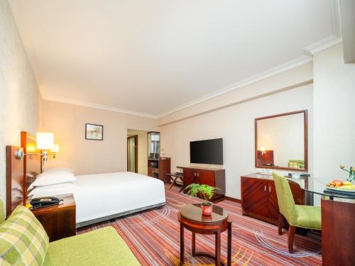 a hotel room with a bed and a tv at Guangzhou Hutian Hotel in Guangzhou