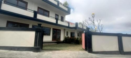 a white building with a fence in front of it at Villa Purnama in Ungasan