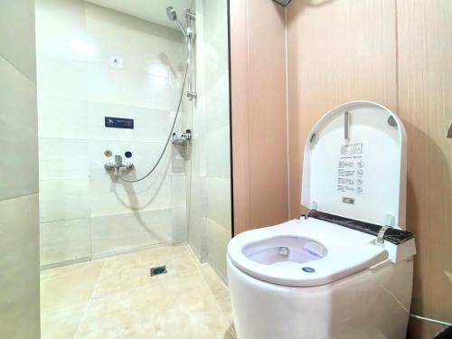 a bathroom with a shower and a toilet with the lid up at 成都格兰朵酒店宽窄巷子店 in Chengdu