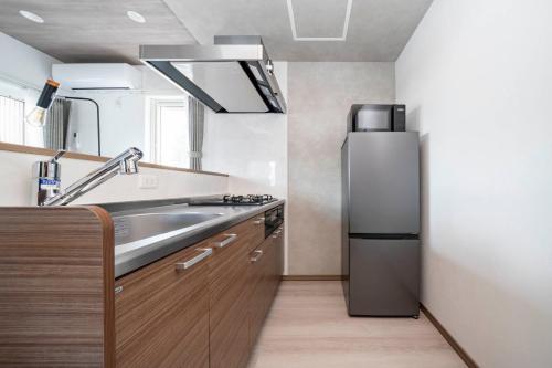 a kitchen with a stainless steel refrigerator and a sink at Mks 101 in Wada