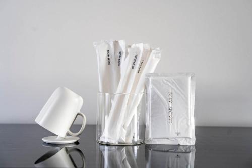 a glass vase filled with white toothbrushes on a table at Mks 101 in Wada