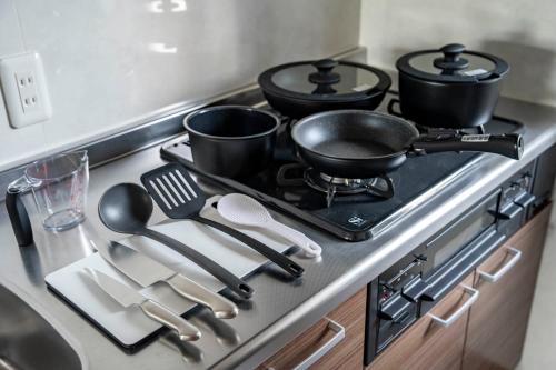 a kitchen stove with three pots and pans on it at Mks 101 in Wada