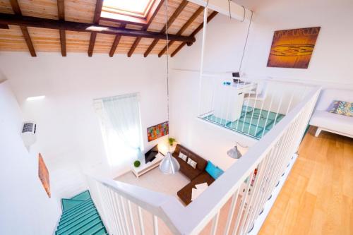 Habitación blanca con escalera y sofá en Via Breda 120, en Milán