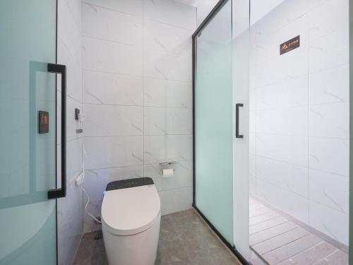 a bathroom with a toilet and a glass door at Ouchen International High altitude Cloud River View Hotel Chongqing Guanyinqiao Beibin 1st Road in Chongqing