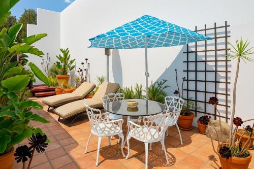 a patio with a table and chairs and an umbrella at The Heart Of Hollywood Hills in Los Angeles